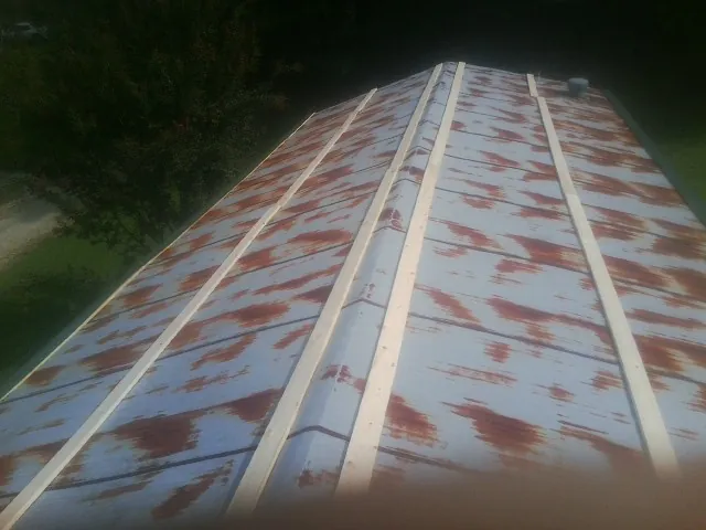 Rusted metal roof panels with new wood purlins before replacement — Storm Damage Roof Repair in Spring Hill by Roofing Brothers